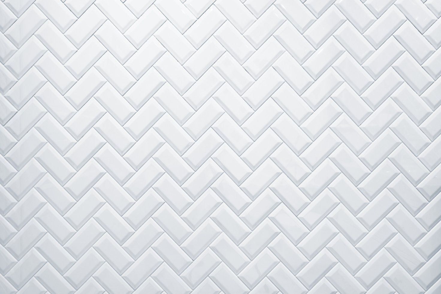 White tile on the wall in the bathroom.